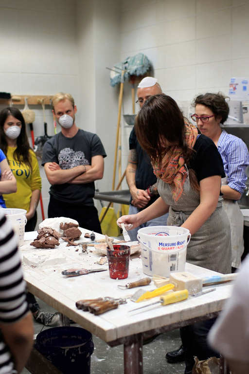 A person leads a ceramics demonstration.