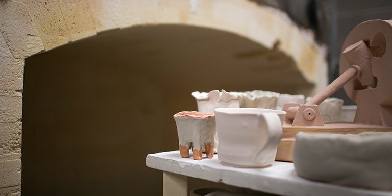 Ceramic pieces in front of a kiln.