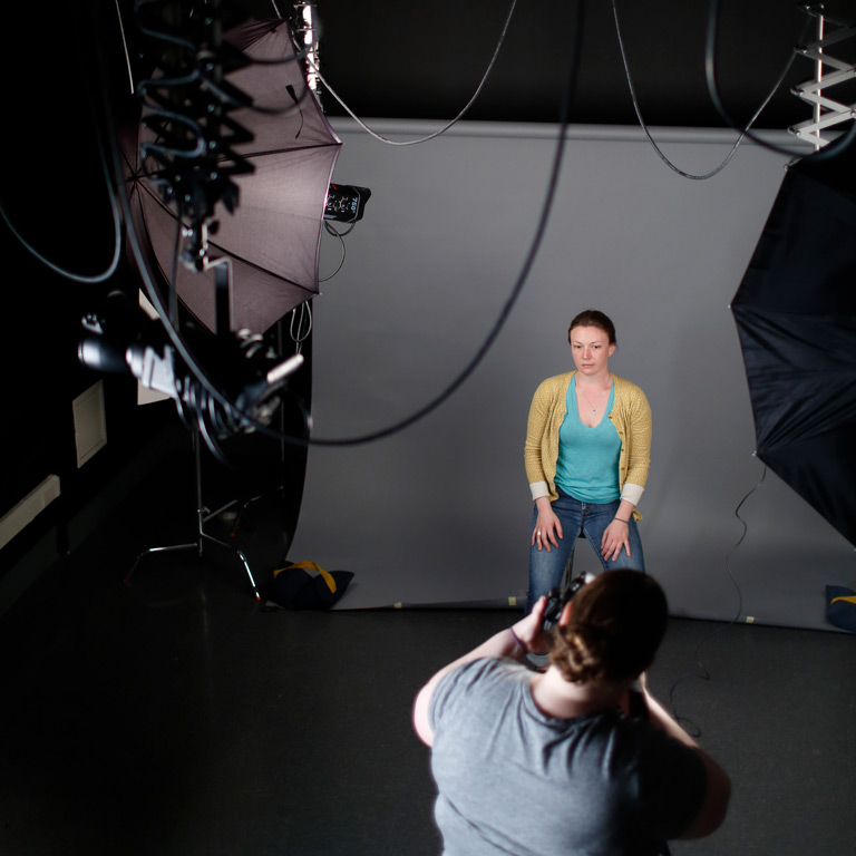 A person poses in a photo studio. 
