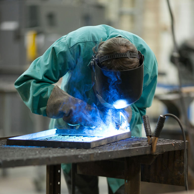 A person using a blowtorch on metal.