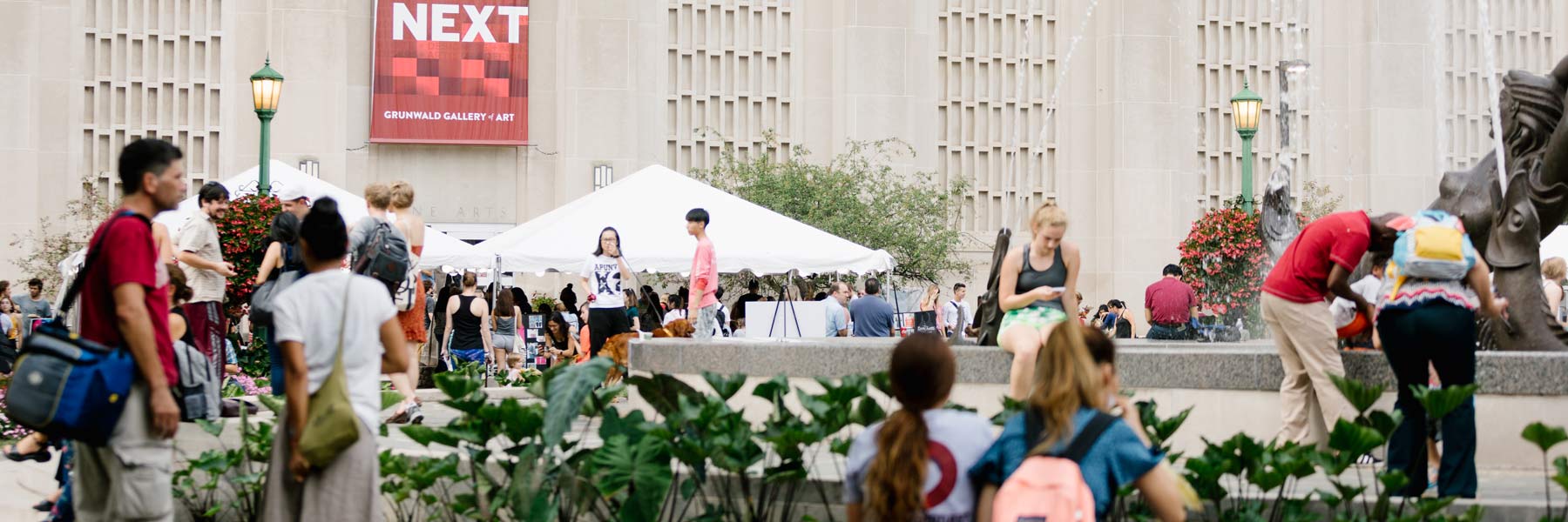 People at an event near a water fountain.