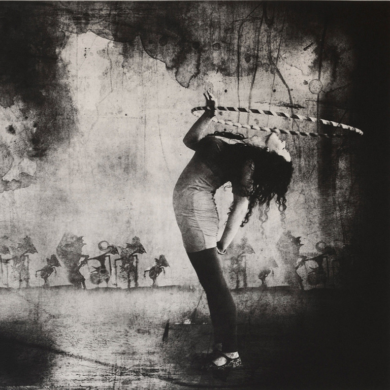 A black and white image of a woman with a hula hoop