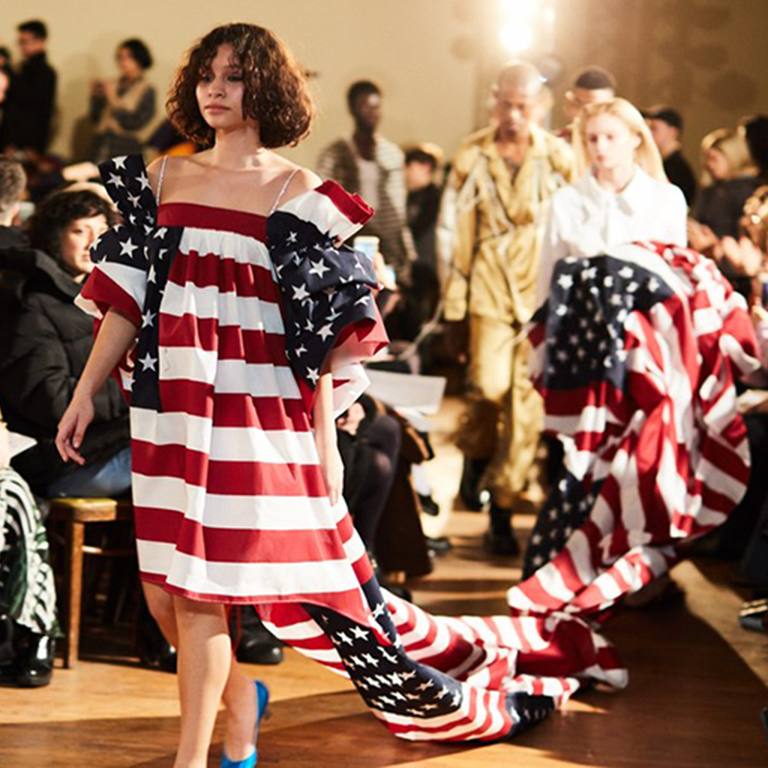 A person walks in a dress that looks like the American flag