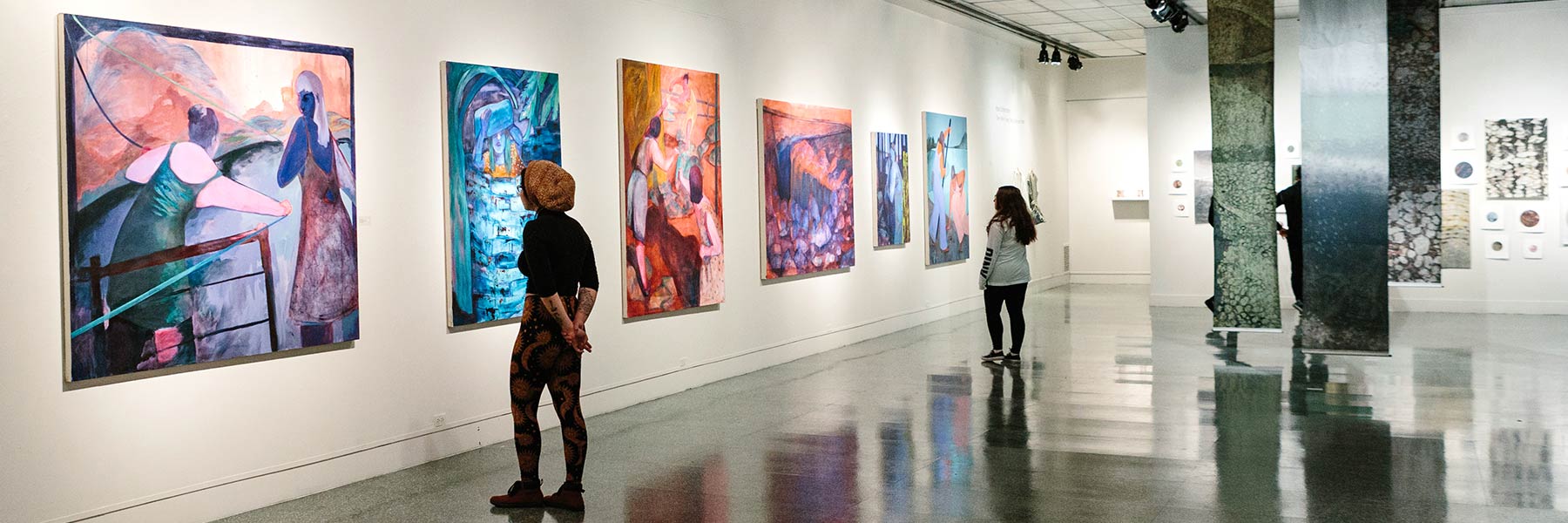 A person looking at paintings in an art gallery.
