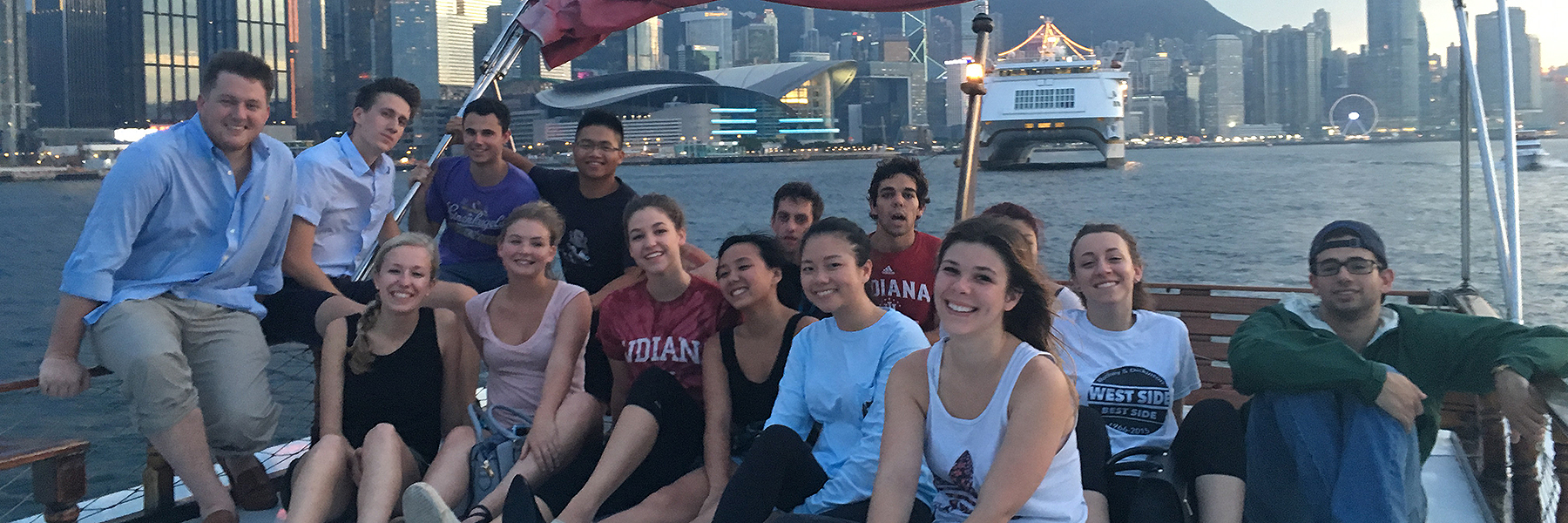 A group poses in front of a river in a big city.