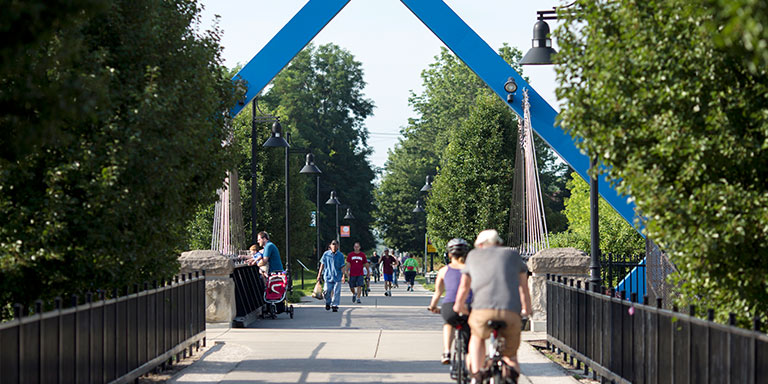 People walk and bike along a paved trail.